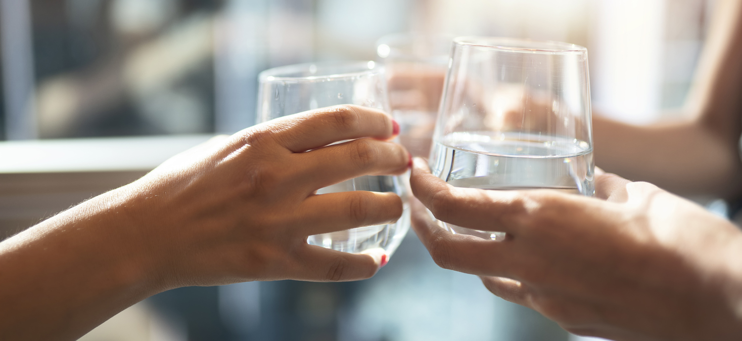 Closeup of women toasting with water glasses